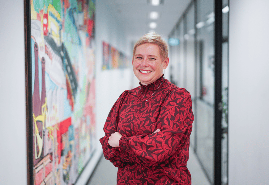 Jo Dutton, Executive General Manager for Technology Transformation at nbn, standing in hallway smiling